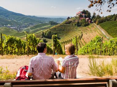 Pärchen macht Rast auf einer Bank in den Weinbergen