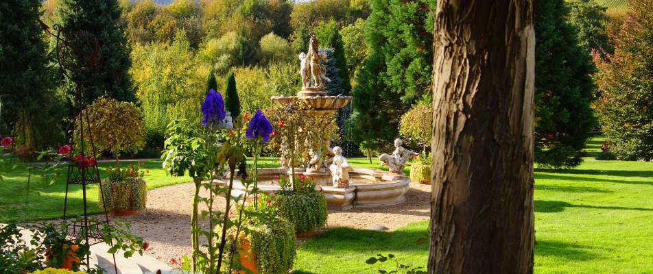 Parkbrunnen in Durbach zwischen Blumen und Bäumen